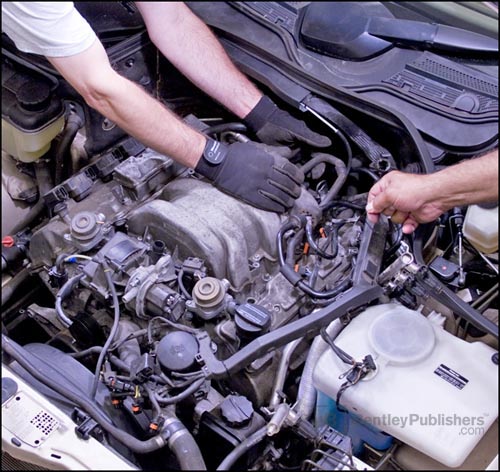 Bentley technical
editors removing intake manifold on V6 (M 112) engine.(BentleyPublishers.com watermark not printed on actual product.)